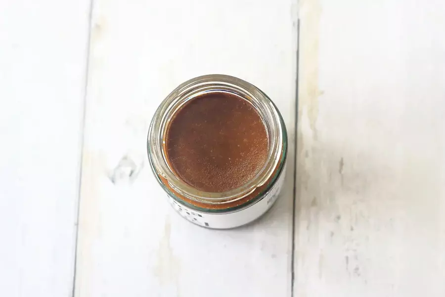 A photograph, taken from above, of an open jar of Peanut Caramel